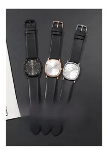 Three men's ultra-thin watches in black, rose gold, and silver on grey texture