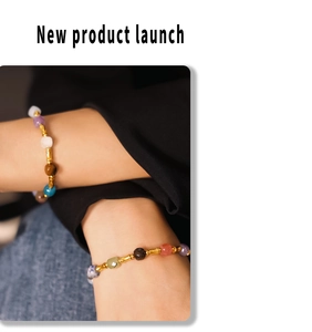 Detailed view of colorful natural stone beaded bracelets with gold bamboo accents on wrist