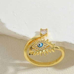Detailed shot of golden adjustable evil eye ring with blue enamel and cubic zirconia