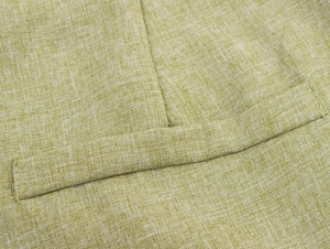 Close-up of light sage green coarse woven fabric showing fine linen texture and stitching