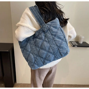 Vue détaillée du grand sac cabas en jean bleu avec surpiqûres à motif de losanges matelassés
