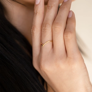 Gold V-shaped titanium steel ring set with a red December birthstone for women