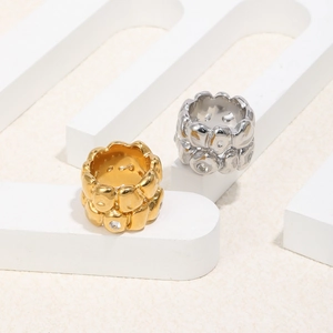 Detail of wide wave textured rings in gold and silver finish with zircon inlays