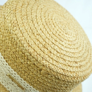 Detailed macro view of woven straw texture with lace trim and golden metal plate