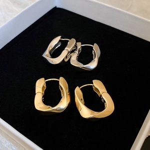 Détail de boucles d'oreilles géométriques torsadées en U en plaqué or et argent