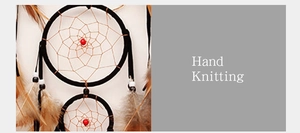 Detail of hand-knitted dreamcatcher featuring double rings, red beads and natural brown feathers