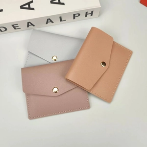 Close-up of minimalist card holders in three colors with snap closure and grain texture