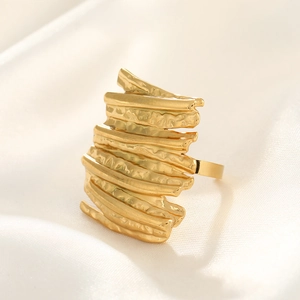 Macro detail of a gold hammered ring showing irregular layered rock textures on the surface