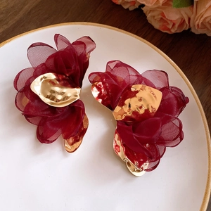 Detailed shot of handmade wine red mesh flower earrings with gold metal accents