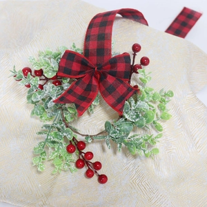 Christmas eucalyptus wreath with red berries and buffalo plaid bow for stair decoration