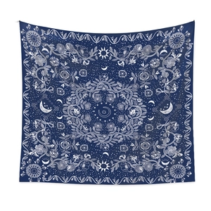 Close-up of bohemian sun and moon mandala pattern on a navy blue fabric tapestry