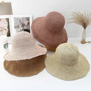 Dettaglio di quattro cappelli in paglia all'uncinetto fatti a mano in vari colori estivi