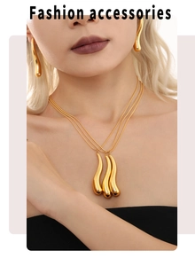 Close-up of a triple-layered gold necklace and droplet earrings fashion set for women