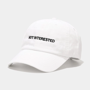 White cotton baseball cap with black Not Interested embroidery and curved brim