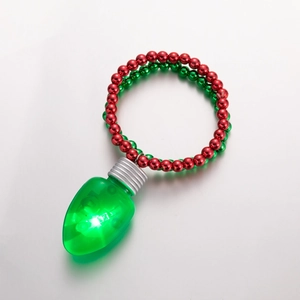 Dettaglio di un bracciale natalizio a doppio strato con lampadine LED verdi e perle rosse