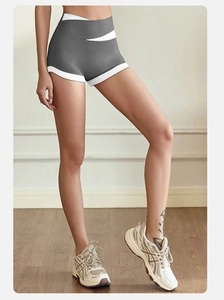 Detail of high-waisted yoga shorts with crossover waist and contrast white piping
