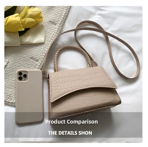 Detailed close-up of beige crocodile pattern handbag with woven handle and strap
