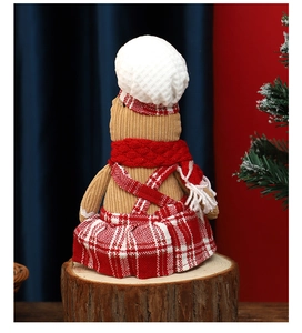 Detailed close-up of a Christmas gingerbread man doll in knitted chef outfit with red scarf