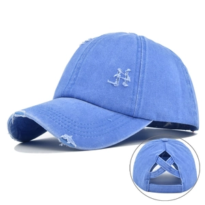 Detailed view of blue distressed ponytail baseball cap with elastic criss-cross back design