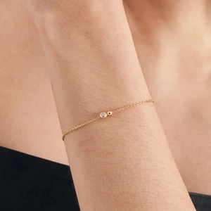Close-up of a delicate gold S925 silver chain bracelet featuring a round sparkling zircon