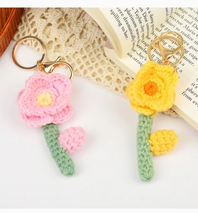 Macro shot of handmade crochet flower keychains in pink and yellow with gold ring