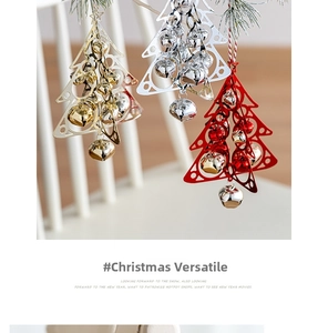 Close-up of metal Christmas tree bell pendants hanging on pine branches for holiday decor