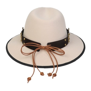Detail of beige fedora hat with brown leather band, gold studs and beaded tassels