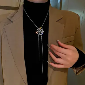 Sautoir camélia avec zircons et design à pompons porté par un mannequin de mode