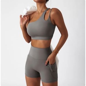 Detail showing high-waisted fitness shorts with side pockets and asymmetrical sports bra