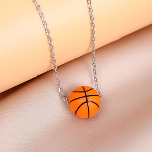 Classic silver chain with vibrant orange basketball pendant on elegant silk fabric