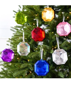 Close-up of multicolored octagonal gem ornaments hanging on a festive Christmas tree