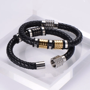 Detail of men's braided leather bracelets featuring stainless steel rings and magnetic clasp