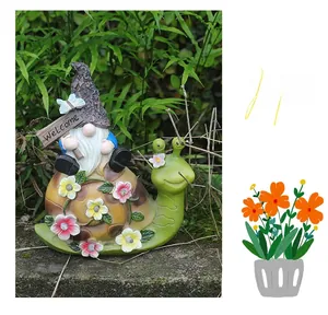 Detail of garden gnome riding a snail with floral LED lights and Welcome sign