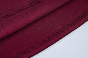Detailed close-up of fine stitching and burgundy jersey fabric texture on summer dress