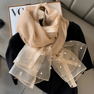 Detail of champagne silk scarf with pearl embellishments on light mesh fabric trim