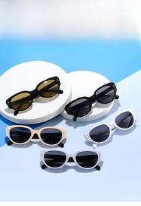 Flat lay of vintage cat eye sunglasses in multiple colors on a blue and white background