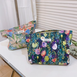 Detail of oil painting floral cotton makeup bags with simple wish labels and metal zippers