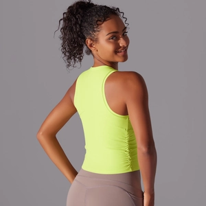 Gros plan d'un débardeur de yoga vert néon montrant le tissu respirant et la coupe