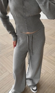 Detail of gray knitted set featuring button-up cardigan and drawstring wide-leg pants