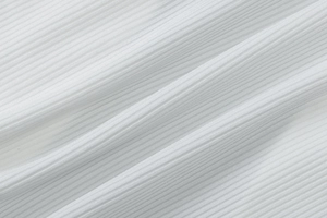 Gros plan sur la texture du tricot blanc côtelé montrant les détails plissés verticaux