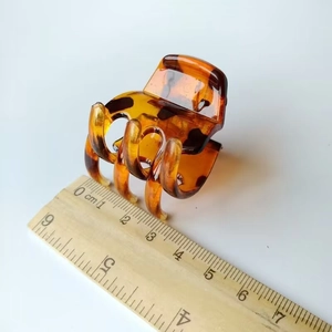 Detail shot of a 3.5cm square tortoiseshell claw clip measured against a wooden ruler