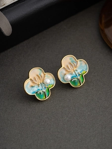 Macro detail of clover earrings with colorful oil painting enamel and small pearls