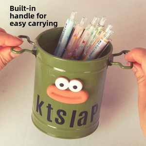 Close-up of military green metal pen holder with handle and cartoon facial detail