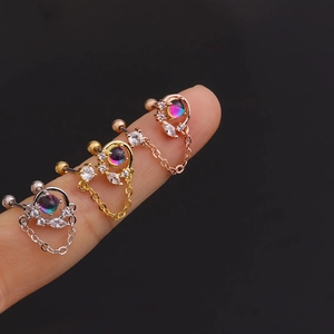 Macro view of colorful zircon stud earrings with chains in gold and silver finish