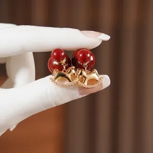 Exquisite gold-plated rocking horse earrings with red spherical charms and zircon stones