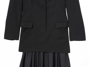 Detail of black blazer dress showing long sleeves, flap pockets and pleated hemline