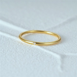 Macro shot of minimalist 18K gold ring featuring a sparkling round-cut cubic zirconia