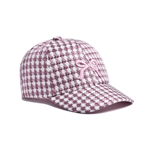 Close-up of pink houndstooth baseball cap with embroidered bow detail on white background
