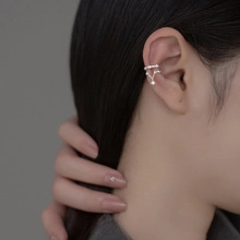 Macro detail of silver-tone double-layer V-shaped ear cuff with sparkling zircon inlay