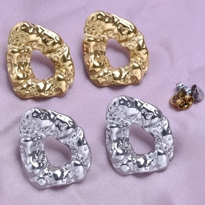 Macro detail of irregular geometric stud earrings with 18k gold hammered texture